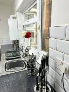 考文垂Modern Town House - Coventry的带水槽的厨房台面和窗户