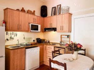 开普敦5营街旅馆及自助公寓的厨房配有木制橱柜和花瓶桌子。