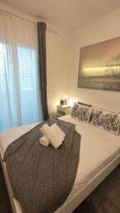 瓦伦西亚Small and Cozy Rooms - G10的一间卧室配有一张床,上面有两条毛巾