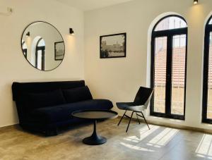 耶路撒冷Lovely New Private Duplex in Prime City Center location的带沙发、桌子和镜子的客厅