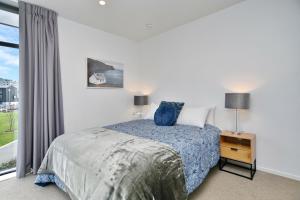 基督城Lichfield Apartment - Christchurch Holiday Homes的一间卧室设有一张床和一个大窗户