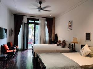 河内Centraltique Downtown - Bespoke Colonial House Near Hoan Kiem Lake的酒店客房配有两张床和吊扇。