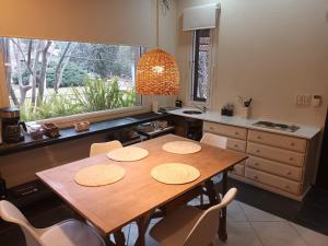 查克拉斯德科里亚La Posadita de Chacras的厨房配有木桌、椅子和窗户