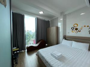 Trung AnHotel Hồng Cẩm的卧室配有白色的床和窗户。