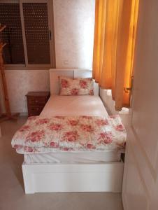 阿加迪尔amal's apart&studio的小卧室配有一张带鲜花毯子的床