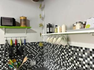 萨比萨比自助公寓的厨房的墙壁上铺有黑白瓷砖。