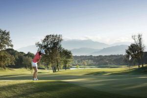 卡尔德斯德马拉维亚Camiral Golf & Wellness - Leading Hotel of the World的女人在高尔夫球场打高尔夫