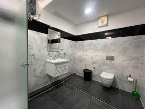亭可马里Aara Holiday Home的白色的浴室设有水槽和卫生间。
