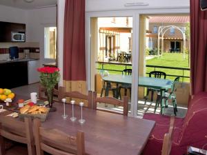 贝尔热拉克Apartment in a picturesque city in the Dordogne的一间设有桌子并享有庭院景色的用餐室