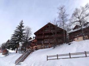 OzApartment on the slopes in the big ski area Grandes Rousses的围栏旁雪地中的滑雪小屋