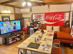 镰仓市Umimachi Seikatsu Koshigoe Minatokan - Vacation STAY 55291v的客厅配有古柯标志和桌子