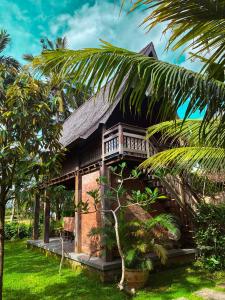 坎古Nunu Bali Eco Friendly Retreat的前面有棕榈树的房子