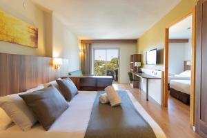 萨洛Golden Avenida Family Suites 4*的酒店客房设有一张沙发和一张床