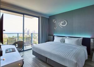 芭堤雅市中心芭提雅格兰德中心大酒店的酒店客房设有一张床和一个阳台。