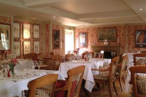 科姆里皇家酒店的餐厅设有白色的桌椅和壁炉