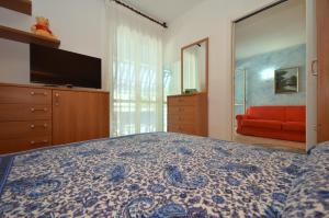 利尼亚诺萨比亚多罗奥林波公寓的一间卧室配有一张床和一张红色的沙发