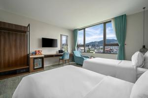 岘港Lupin Boutique Hotel Danang的酒店客房配有一张床、一张书桌和一台电视。