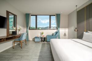 岘港Lupin Boutique Hotel Danang的酒店客房,配有一张床、一张桌子和椅子