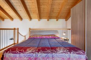 多马索Jack House的卧室内的一张床铺,设有木制天花板
