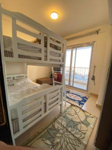 阿莱曼porto marina north coast alamein的卧室配有白色双层床和大窗户