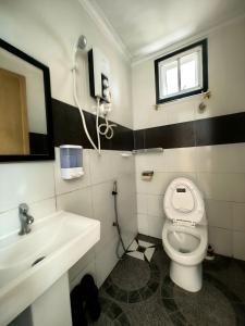 昆达桑KUNDASANG MOUNT GARDEN的浴室配有白色卫生间和盥洗盆。