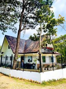 碧瑶Melia's House Baguio - Nature Home for Rent的一座白色的房子,有金属屋顶和栅栏