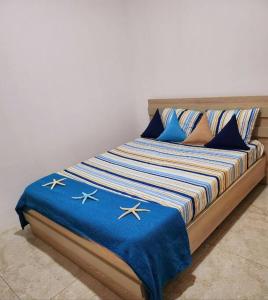 弗利康弗拉克Kot Nu - Beach Themed Apartment - 3 mins walk from the sea的一张带蓝色和白色毯子及枕头的床