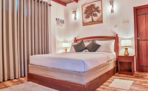 锡吉里亚Tepraas Sigiriya的一间卧室配有带白色床单和枕头的床。