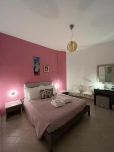 夏卡Colibri B&B的一间卧室配有一张床和粉红色的墙壁