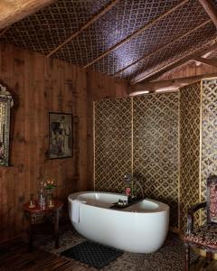 查姆布里陶德博伊斯涅德城堡酒店的配有木墙的客房内设有浴缸。