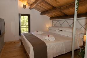 贝尔韦代雷Villa Tatai Country House by Dimore Trinacria的一间卧室配有带毛巾的床