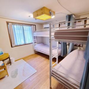 首尔Batwo Stay - For foreigners only的客房设有两张双层床和一扇窗户。