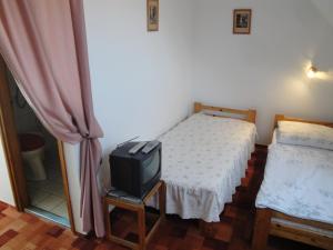 索普隆Guest house Ringhofer Vendégház的一间卧室设有两张床和椅子上的电视