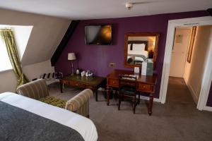 浦耳Antelope by Greene King Inns的酒店客房配有书桌、床和镜子
