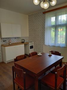 德辛Vila Kotlářská的一间带木桌和椅子的厨房和一间带桌子的厨房