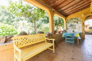 贝加德圣马特奥Villa Ojuelos的一张木凳,坐在带桌子的庭院