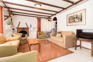 贝加德圣马特奥Villa Ojuelos的带沙发、电视和壁炉的客厅