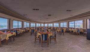 卡萨布兰卡hotel tropicana的用餐室设有桌椅和窗户。