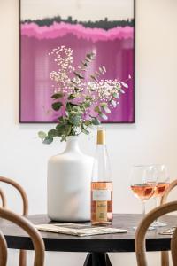 特拉维夫Mate GEORGE - By HOMY的一瓶葡萄酒和一瓶花在桌子上
