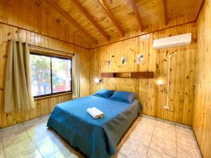 伊瓜苏港Blusky Lodge的木制客房内的一间卧室,配有一张床