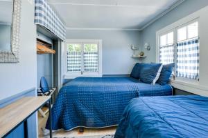 阿瓦隆Charming Catalina Gem with Deck Walk to the Beach!的配有两张床铺的蓝色墙壁和窗户