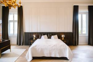 埃伦豪森Georgi Schloss - Boutique Hotel的卧室配有一张带两张桌子的大型白色床