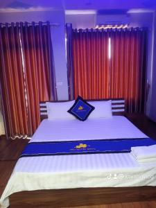 An KhêĐiêu Thuyền Motel的一间卧室配有一张带红色窗帘的大床