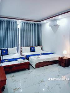 An KhêĐiêu Thuyền Motel的一间卧室配有两张床和一张桌子