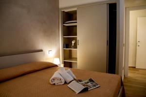 阿格里真托Fiore dei Templi - luxury suite experience的一间卧室配有带毛巾和书籍的床
