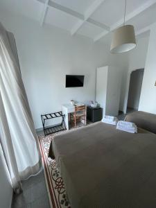 卡普里La Musa的一间卧室配有一张床、一张桌子和一台电视