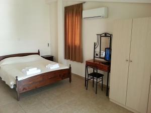 拉纳卡圣拉萨洛斯公寓的一间卧室配有一张床和一张书桌及电视