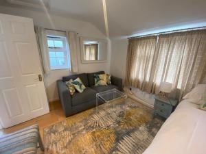 HordleThe Guesthouse hideaway的带沙发和窗户的客厅