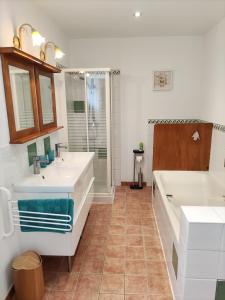 克莱尔沃雷拉克Villas du Lac的浴室配有2个盥洗盆、浴缸和淋浴。