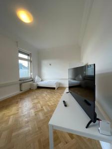 门迪希Schicke Monteurunterkunft in Mendig mit drei Wohneinheiten的白色的大房间,设有白色桌子和窗户